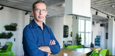 En mann står med armene foldet. Foto